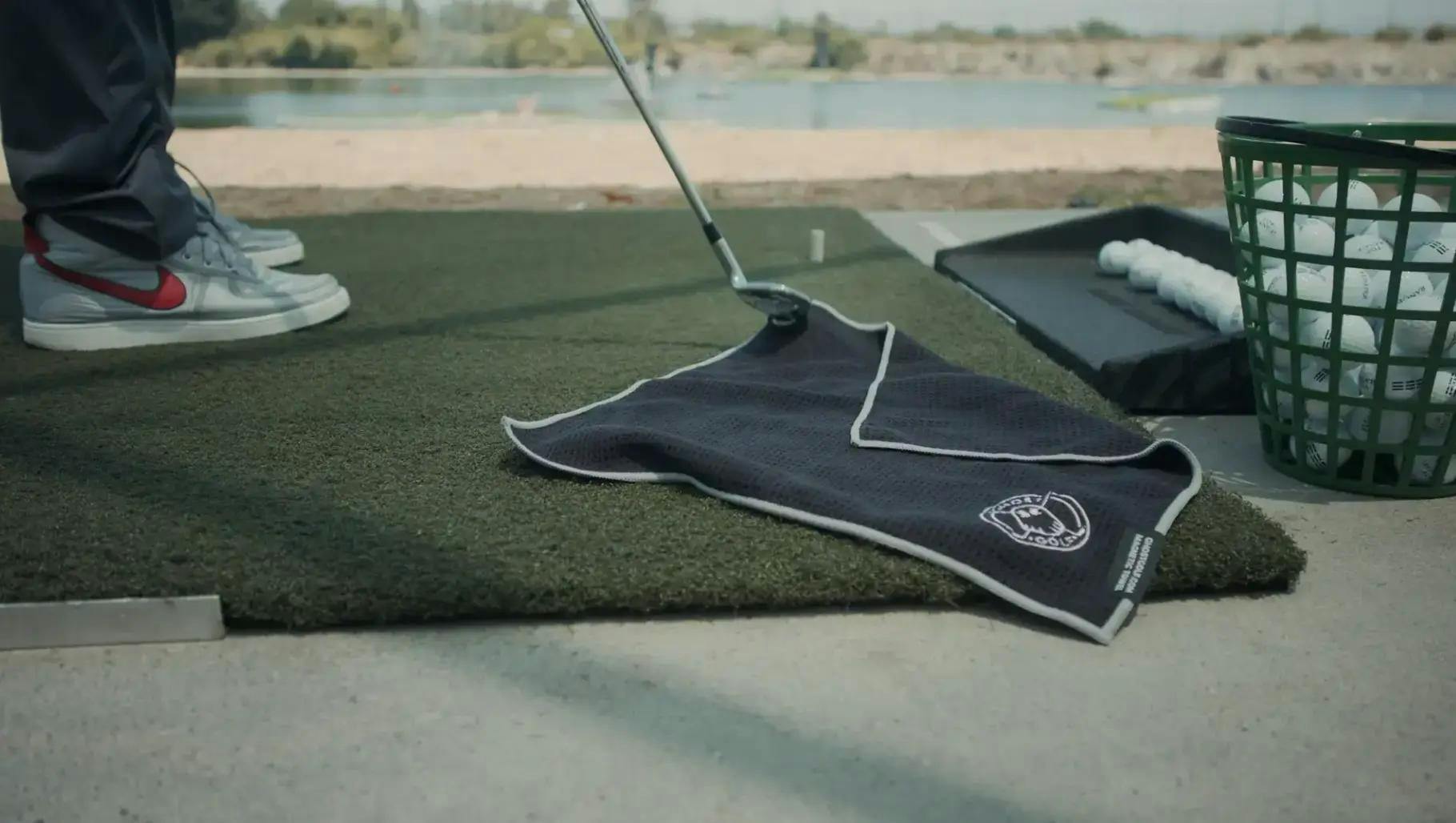 Una toalla de Ghost Golf en el suelo de un campo de prácticas 